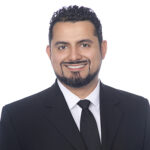 Smiling bearded man in black suit and tie