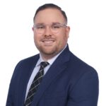 Smiling man in navy suit and glasses